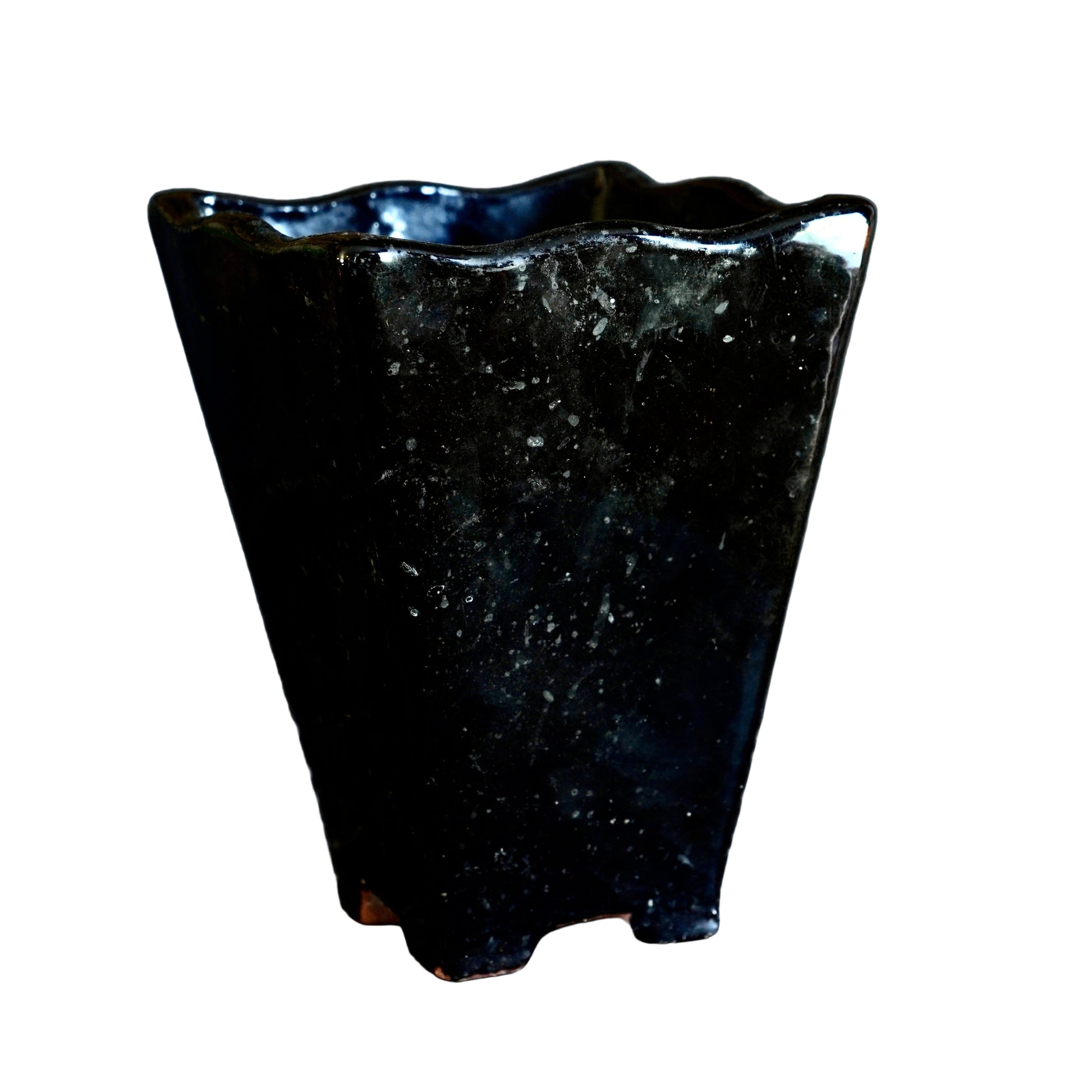 Black stone vase on a dark surface with a dark background