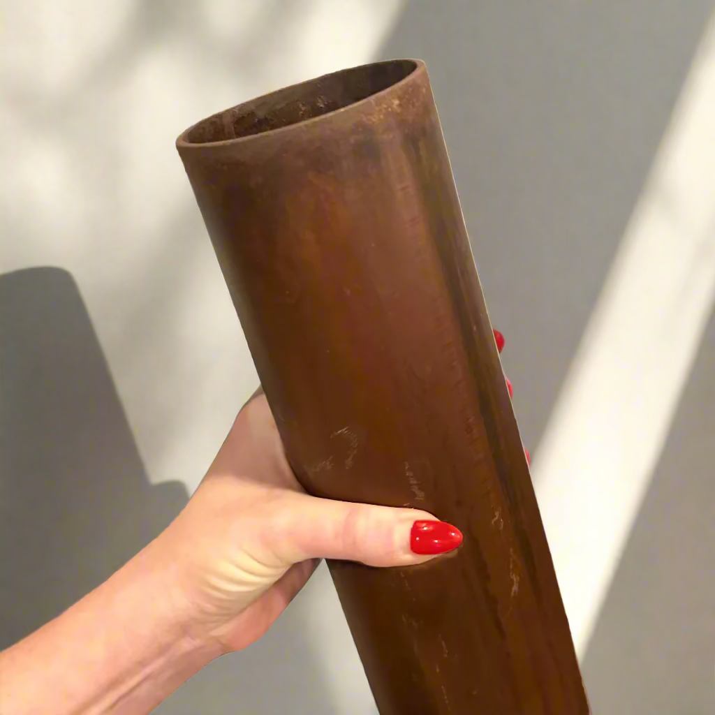 Person holding a metal vase