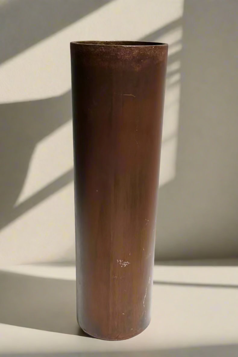 Bronze cylindrical vase on a white background