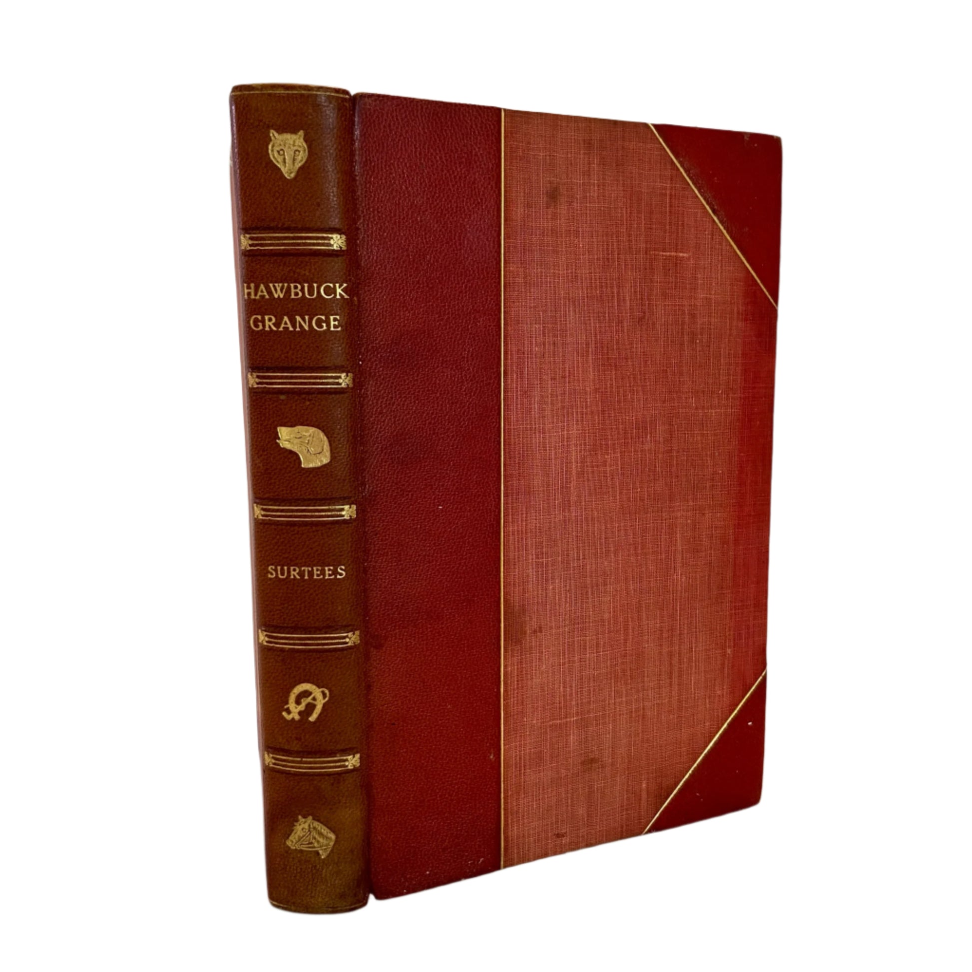 An 1847 edition of 'Hawbuck Grange' with half red leather binding and decorative gold details on the spine.